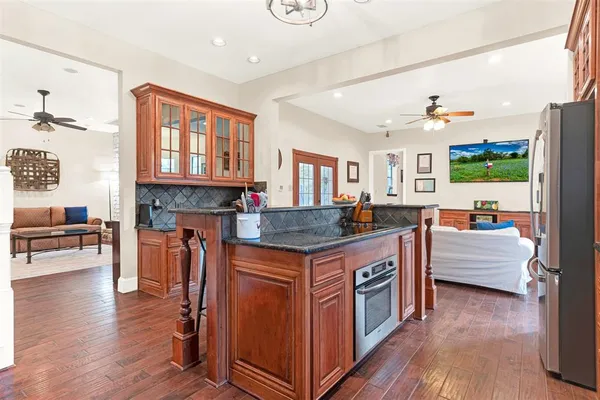 a kitchen with stainless steel appliances granite countertop a stove and a wooden floors