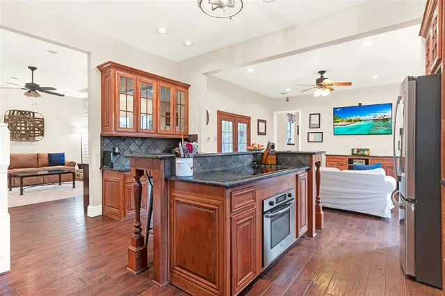 a kitchen with stainless steel appliances granite countertop a stove and a wooden floors