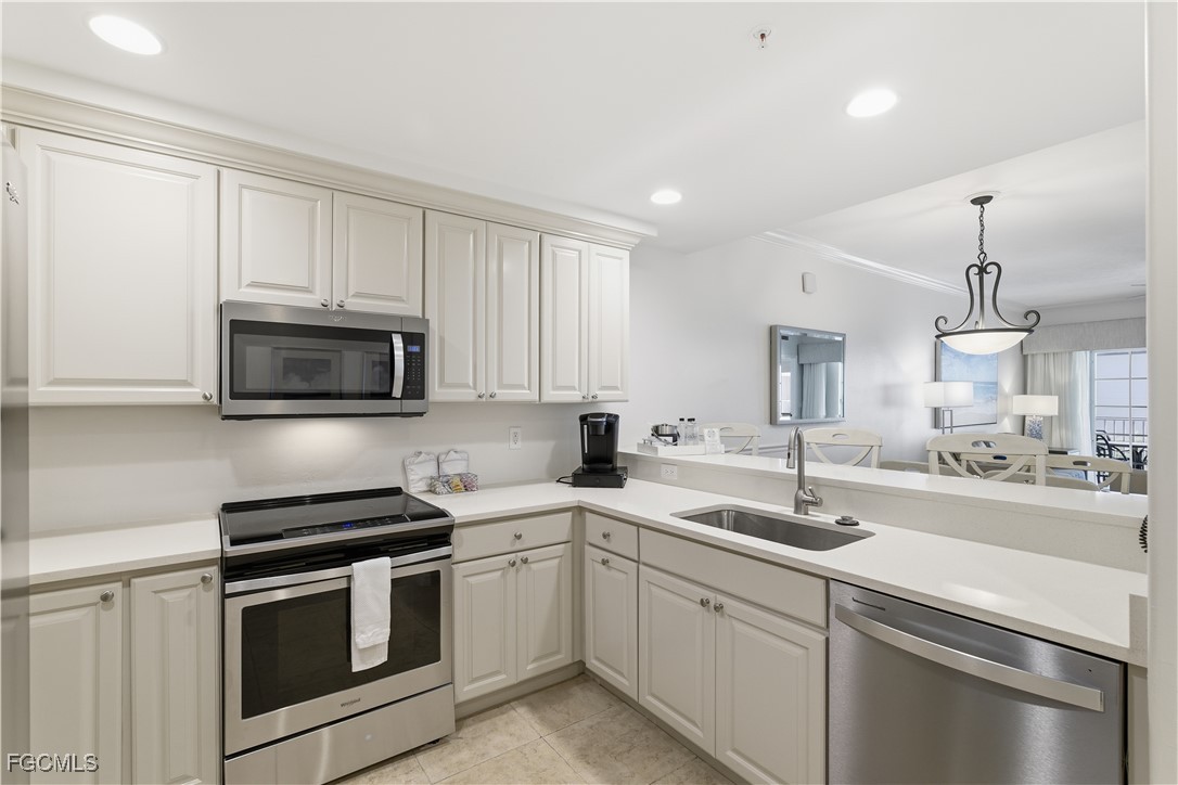 221 9th Street South, Unit 207 Naples, FL 34102 - Photo 16 of 38 a kitchen with a sink stove and microwave