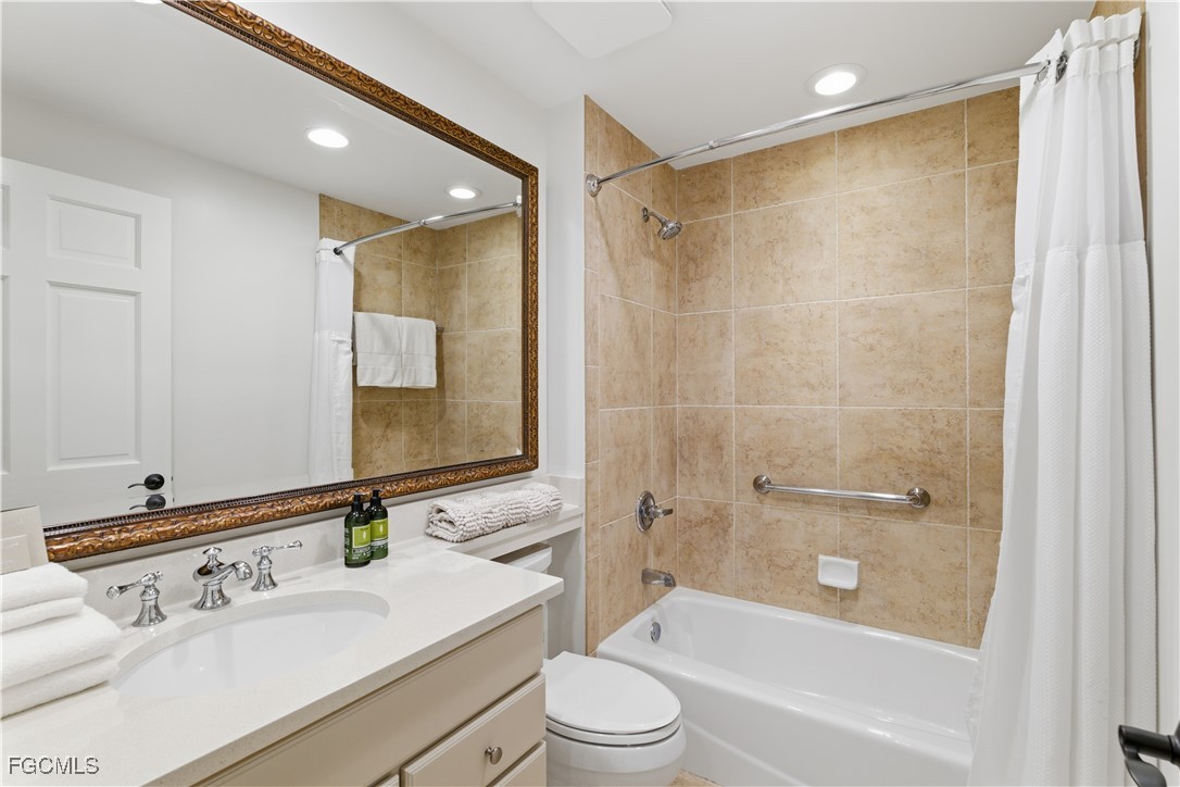 221 9th Street South, Unit 207 Naples, FL 34102 - Photo 20 of 38 a bathroom with a bathtub shower sink vanity mirror and toilet