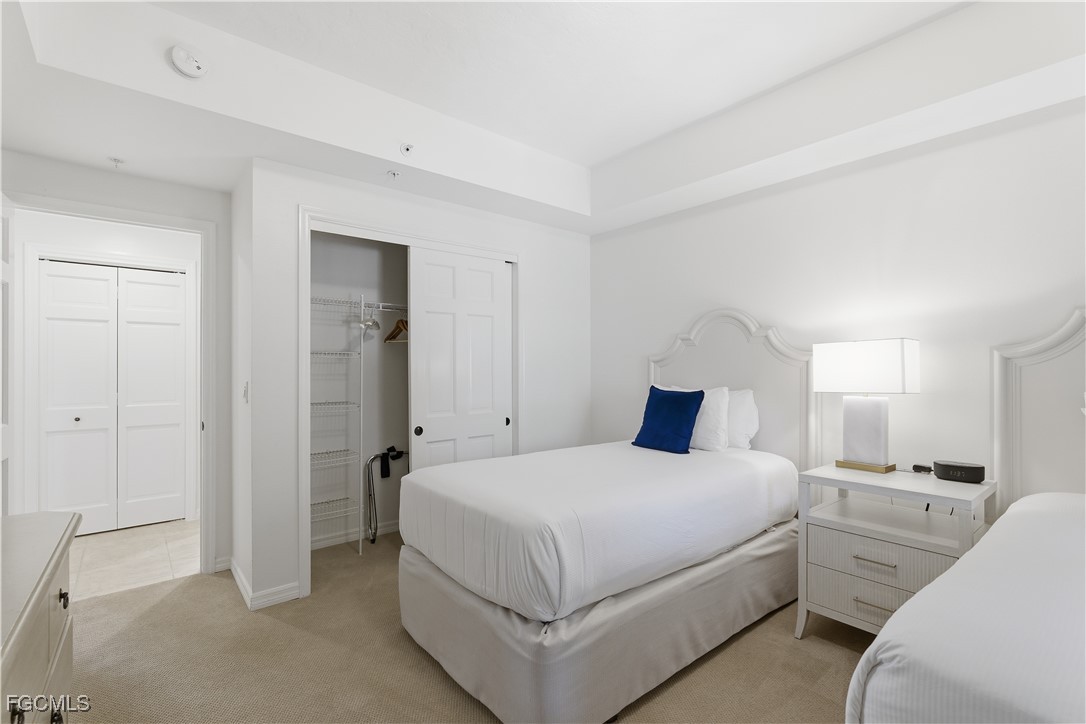 221 9th Street South, Unit 207 Naples, FL 34102 - Photo 21 of 38 a bedroom with a bed and a large mirror