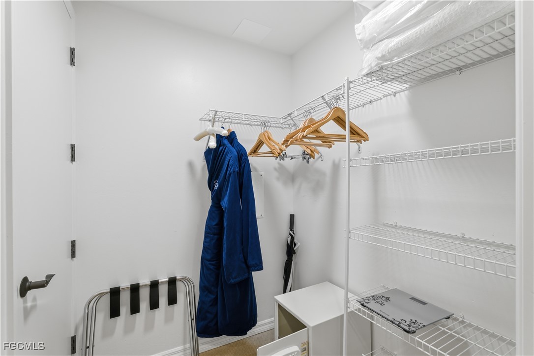 221 9th Street South, Unit 207 Naples, FL 34102 - Photo 24 of 38 a view of walk in closet with clothes and shoes