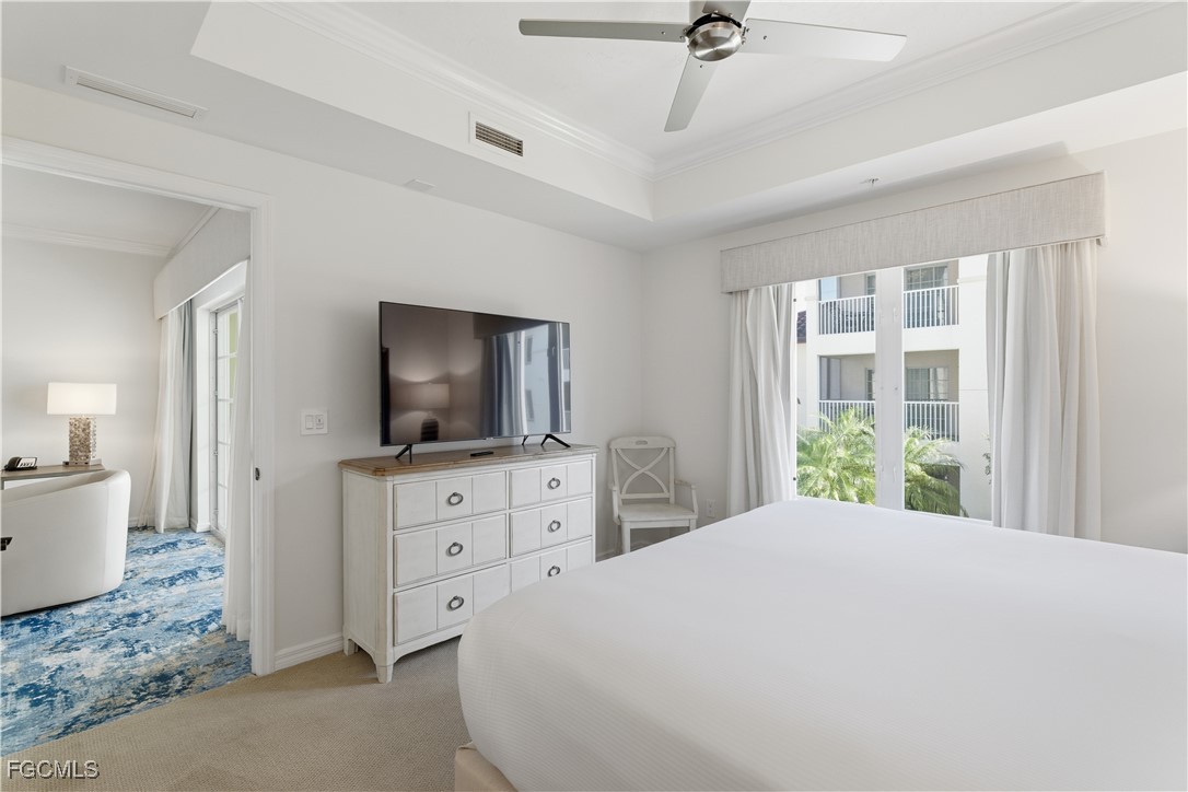 221 9th Street South, Unit 207 Naples, FL 34102 - Photo 26 of 38 a bedroom with a large bed and a flat tv screen on dresser