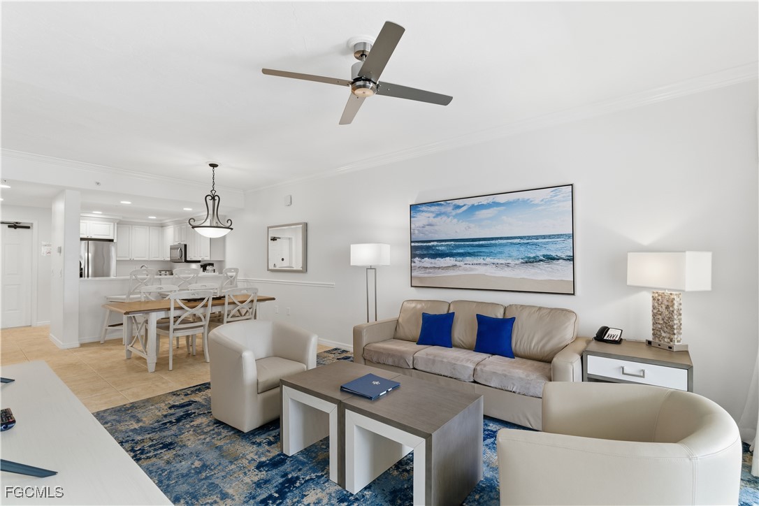 221 9th Street South, Unit 207 Naples, FL 34102 - Photo 5 of 38 a living room with furniture a rug and a chandelier