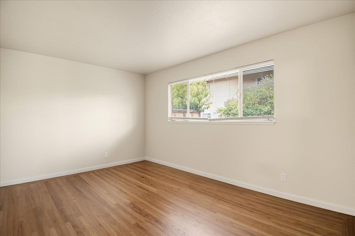 1198 Boranda Avenue Mountain View, CA 94040 - Photo 13 of 38 an empty room with wooden floor and windows