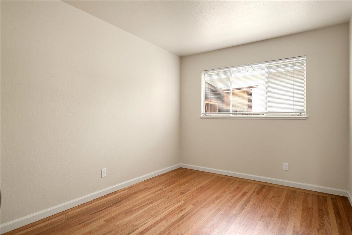 1198 Boranda Avenue Mountain View, CA 94040 - Photo 15 of 38 an empty room with wooden floor and windows