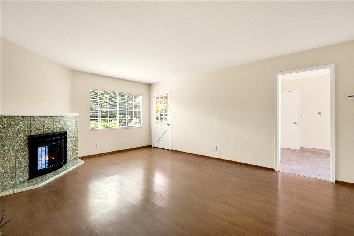 1198 Boranda Avenue Mountain View, CA 94040 - Photo 18 of 38 an empty room with wooden floor fireplace and windows