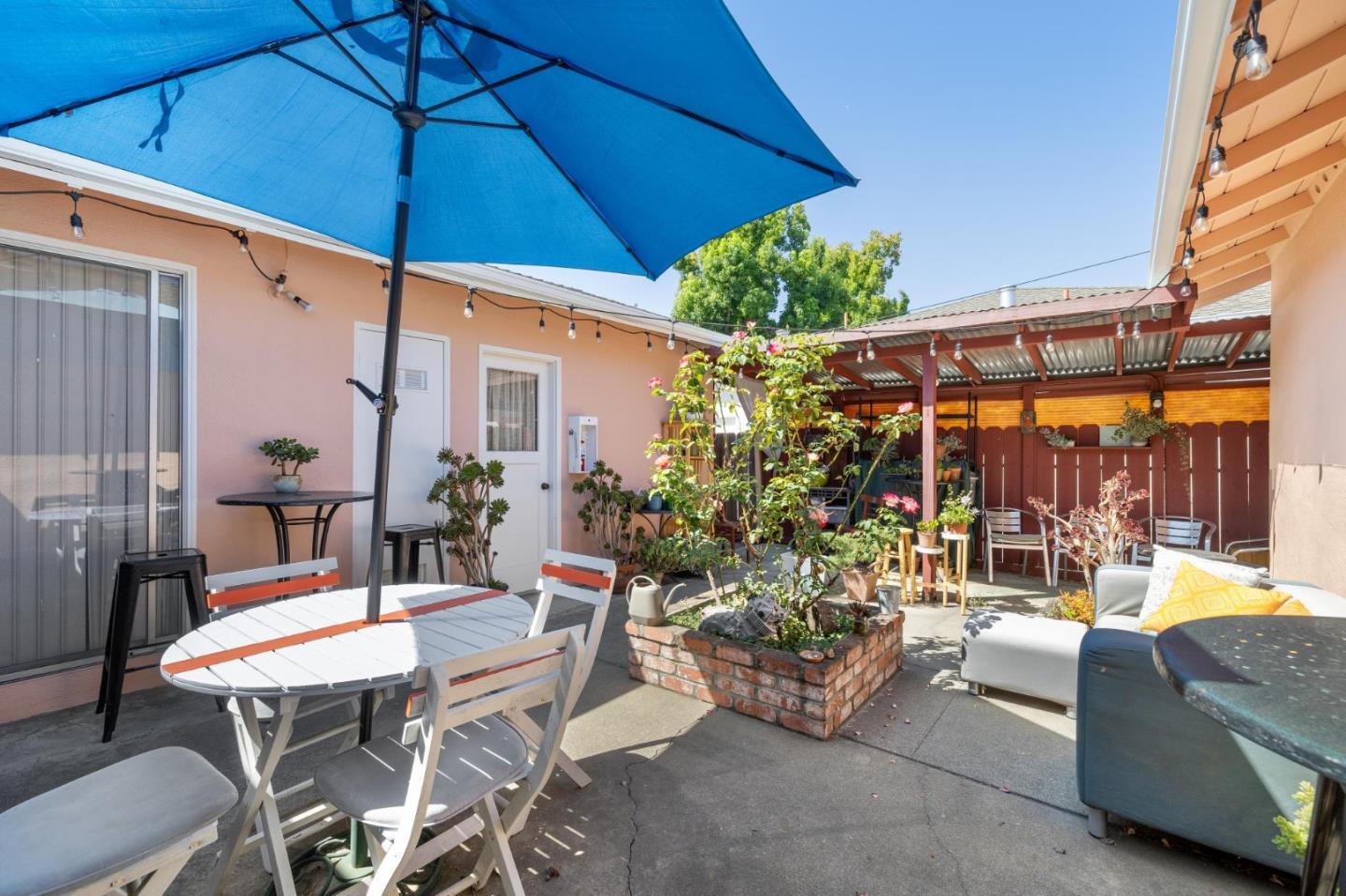1198 Boranda Avenue Mountain View, CA 94040 - Photo 28 of 38 a view of a patio with couches table and chairs under an umbrella