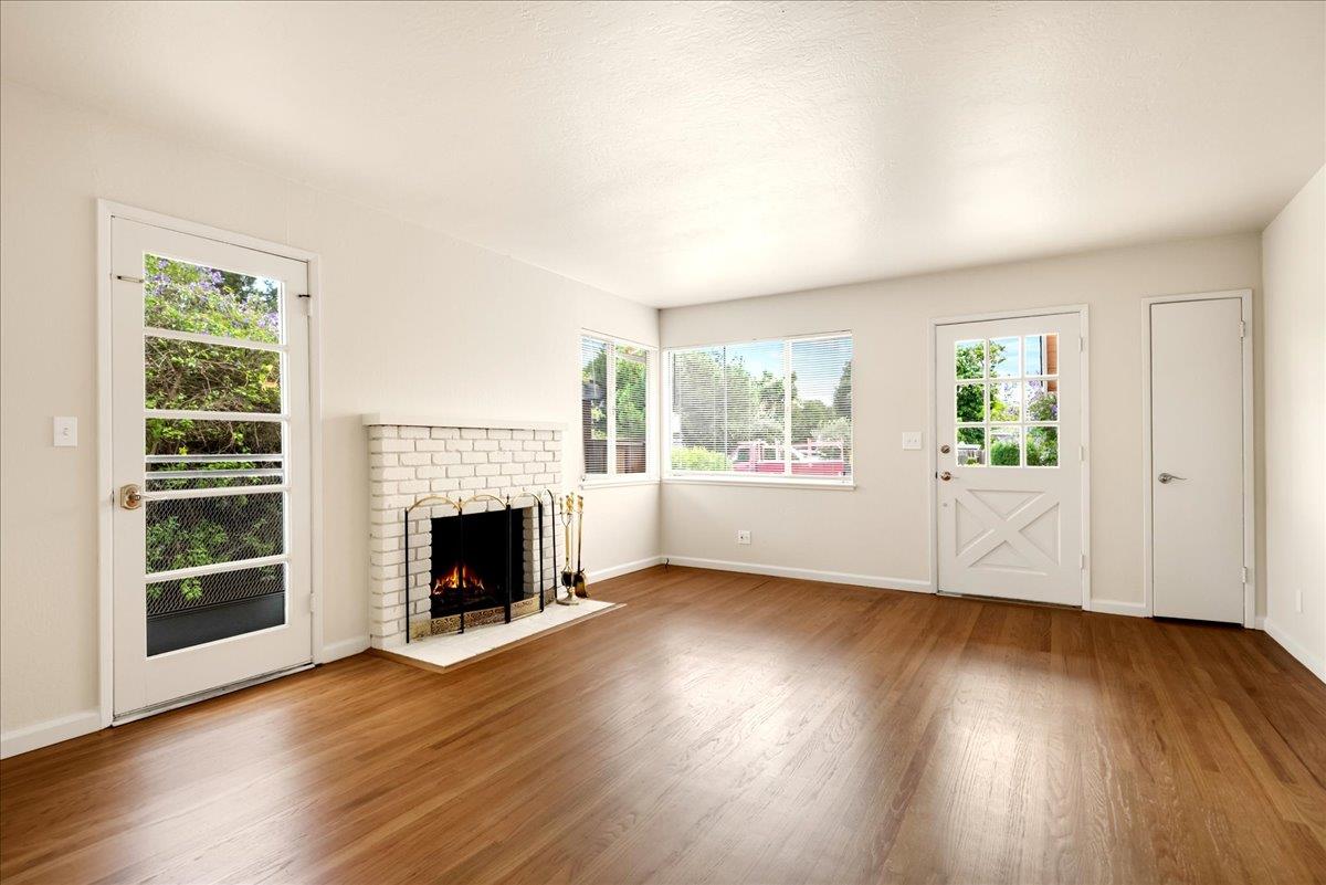 1198 Boranda Avenue Mountain View, CA 94040 - Photo 9 of 38 an empty room with wooden floor fireplace and windows