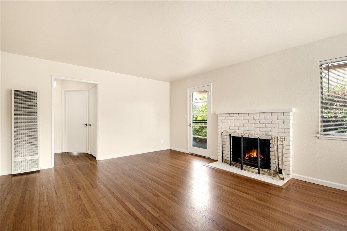 1198 Boranda Avenue Mountain View, CA 94040 - Photo 10 of 38 an empty room with wooden floor fireplace and windows