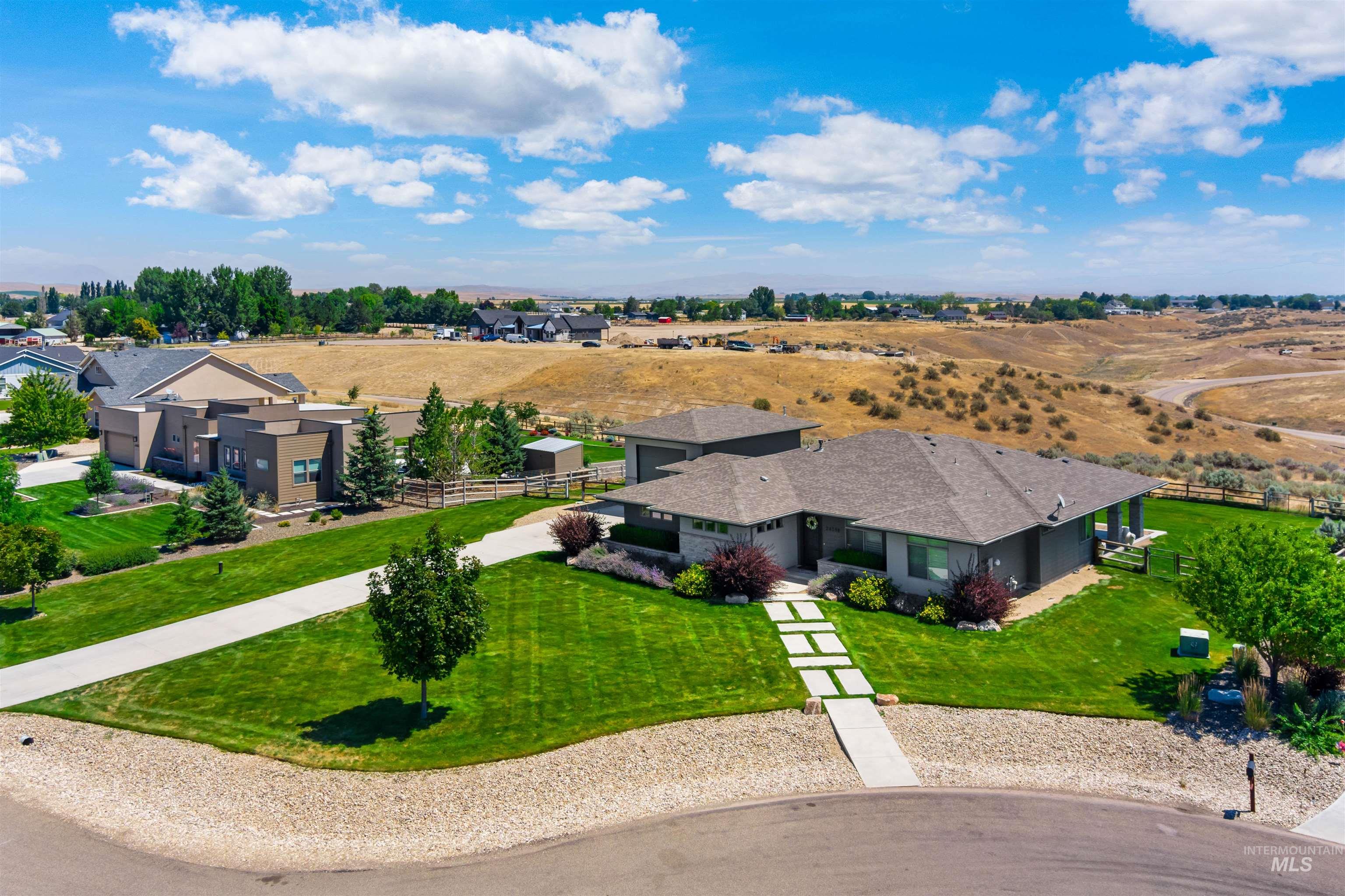 24398 Tombstone Ridge Court Middleton, ID 83644 - Photo 33 of 47 Contemporary-style residence featuring a dark gray exterior, multiple gables, and a prominent front entrance with a stepping stone pathway