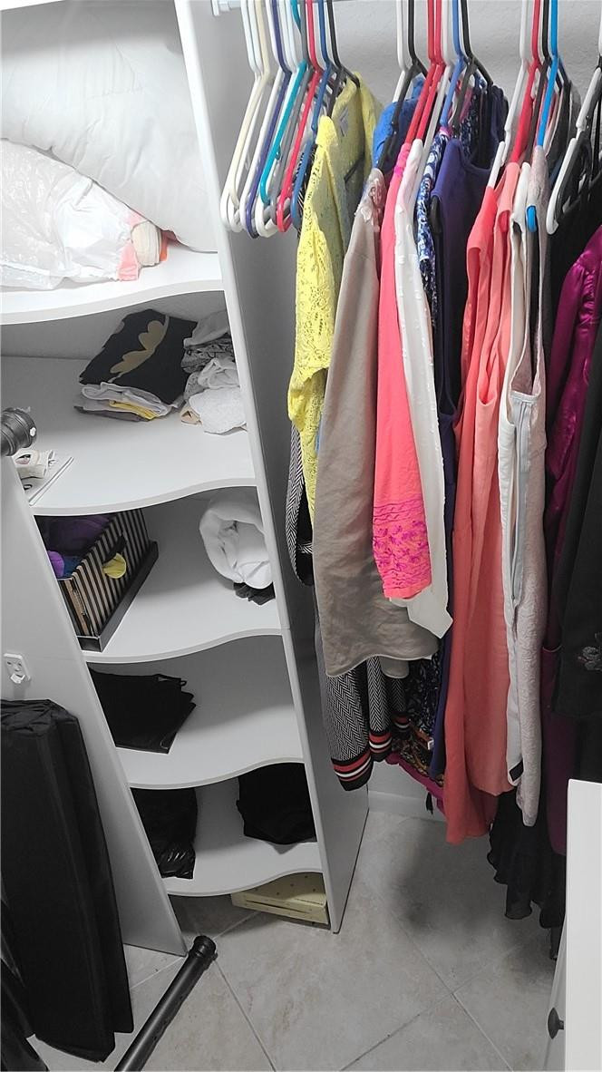 620 Northwest 13th Street, Unit 13 Boca Raton, FL 33486 - Photo 10 of 11 a view of walk in closet with clothes and shoes