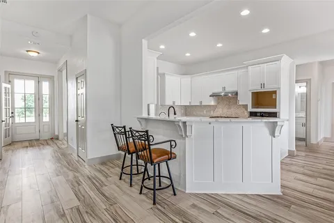 a kitchen with stainless steel appliances kitchen island granite countertop a stove a sink and a refrigerator
