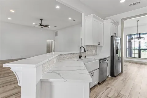 a kitchen with stainless steel appliances a refrigerator sink and wooden floor
