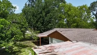 a view of house with roof deck and yard