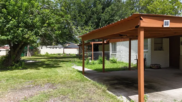 a view of a house with backyard and a tree