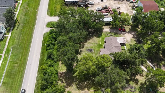 an aerial view of a house with a yard and trees