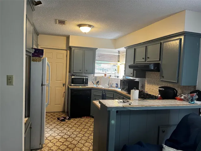 a kitchen with a sink appliances and cabinets