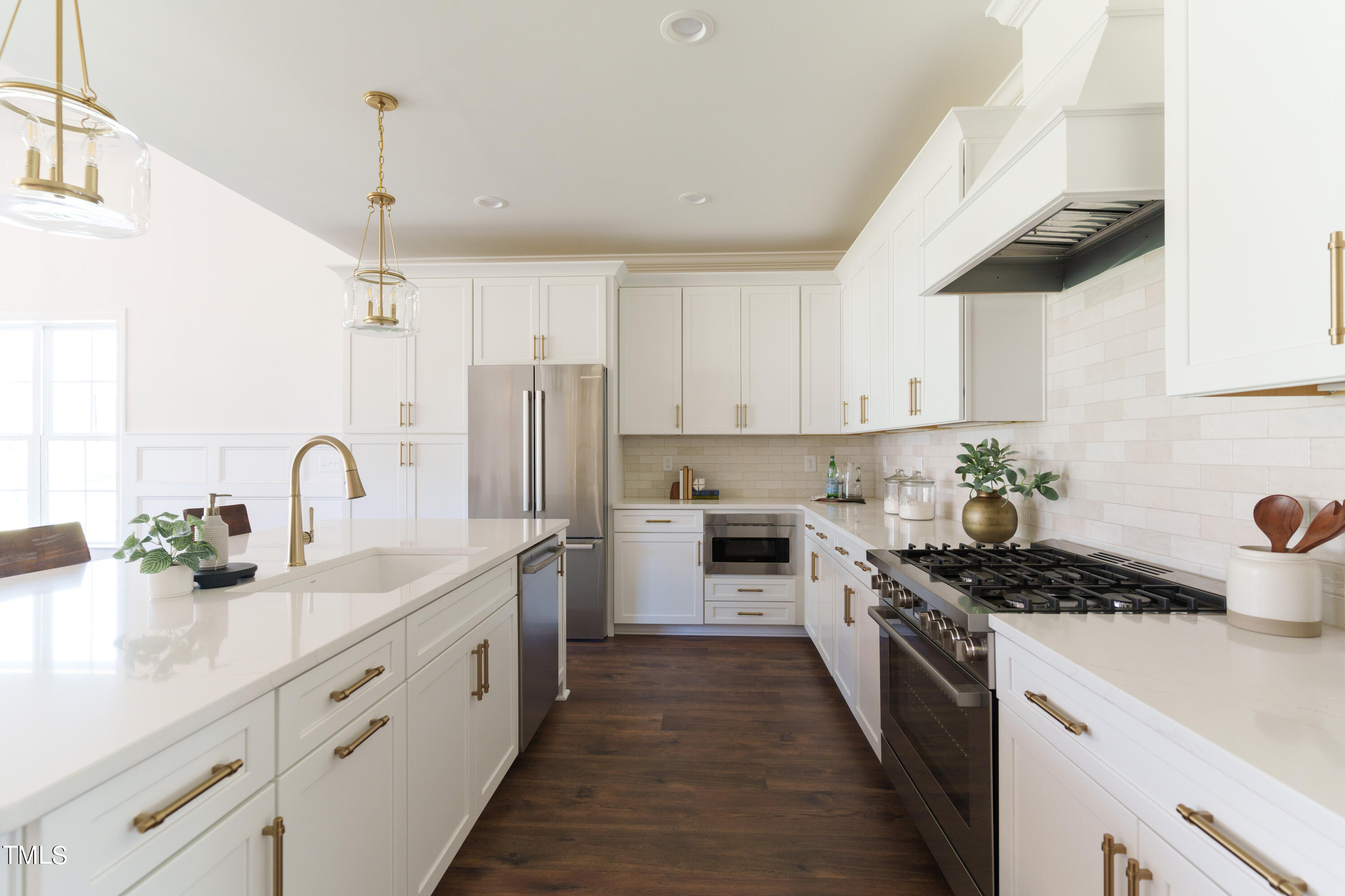 2337 Pearces Road Zebulon, NC 27597 - Photo 17 of 41 a kitchen with stainless steel appliances a sink dishwasher a stove and white cabinets with wooden floor