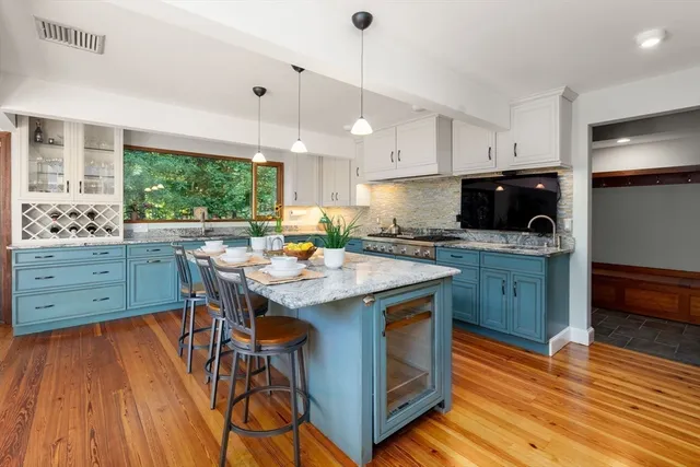 a kitchen with a sink a stove a dining table and chairs