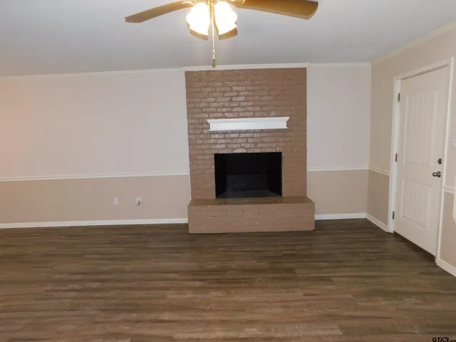 a living room with wooden floor and a fireplace