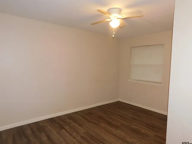 a view of a room with wooden floor and a ceiling fan
