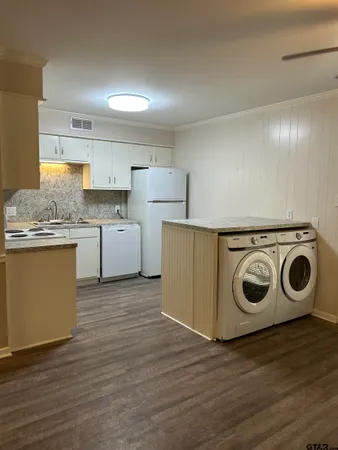 a view of a kitchen with wooden floor and stainless steel appliances