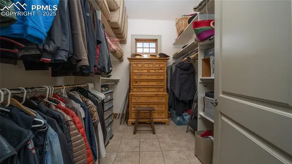 a view of walk in closet with clothes and shoes