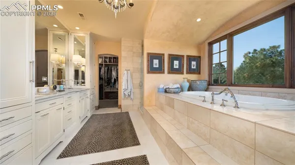 a large white kitchen with a large window and stainless steel appliances
