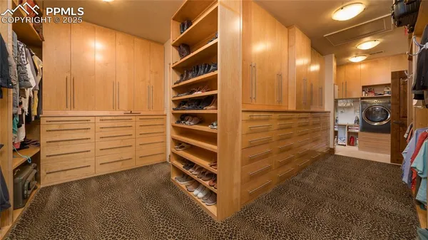 a view of walk in closet with clothes and shoes