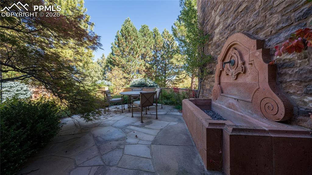 4896 Stonehill Road Colorado Springs, CO 80918 - Photo 5 of 42 a view of backyard with a table and chairs and a large tree