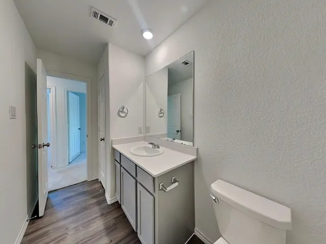 a bathroom with a toilet a sink a mirror and a shower