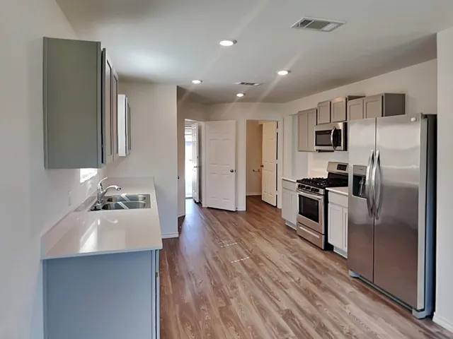 a kitchen with refrigerator a sink and stove