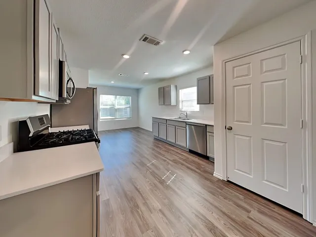 a kitchen with stainless steel appliances granite countertop a stove a sink and a refrigerator