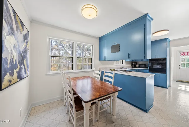 a dining room with furniture a large window and a chandelier