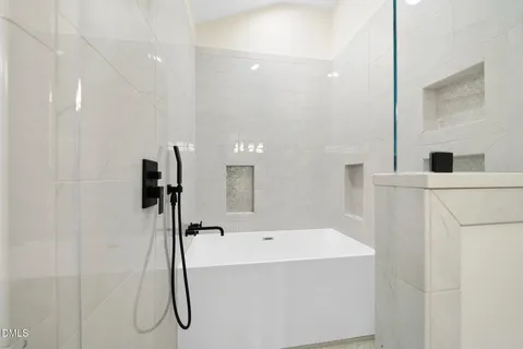 a bathroom with a tub sink and mirror