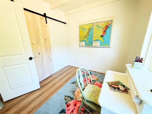 a view of a room with furniture and wooden floor