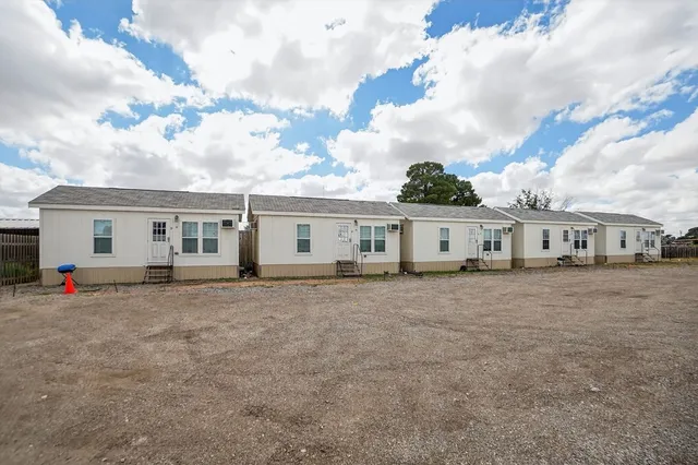 a view of a house with backyard and a tree