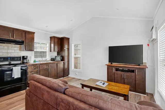 a living room with furniture a flat screen tv and a window