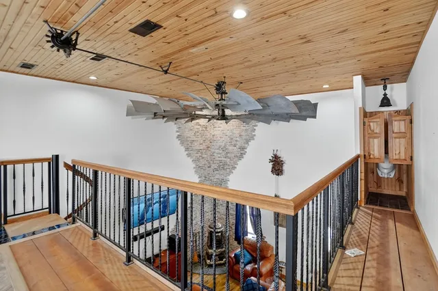 a room with wooden floors pool table and windows