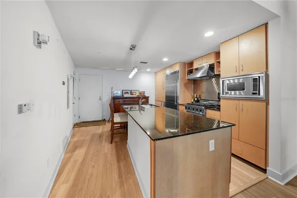 a kitchen with stainless steel appliances granite countertop a sink a stove and a refrigerator