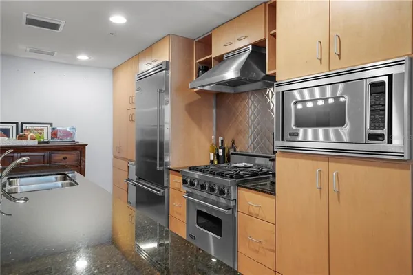 a kitchen with stainless steel appliances granite countertop a stove and a refrigerator