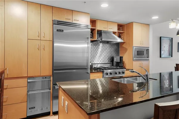a kitchen with stainless steel appliances granite countertop a refrigerator and a stove
