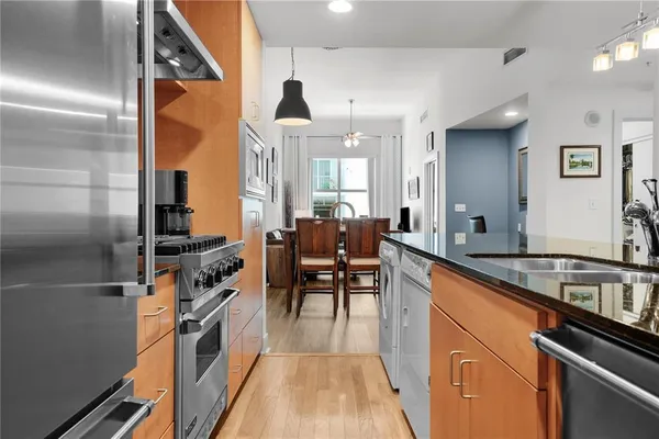 a kitchen with furniture a counter top space a sink a refrigerator and chairs