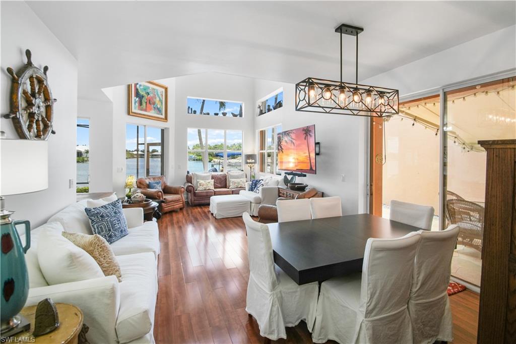 172 Eveningstar Cay Naples, FL 34114 - Photo 6 of 24 a living room with furniture or chandelier and a wooden floor