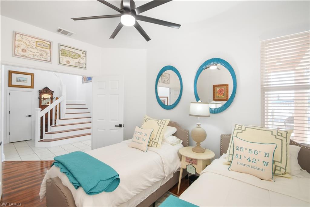 172 Eveningstar Cay Naples, FL 34114 - Photo 10 of 24 a bedroom with 2 bed and a chandelier