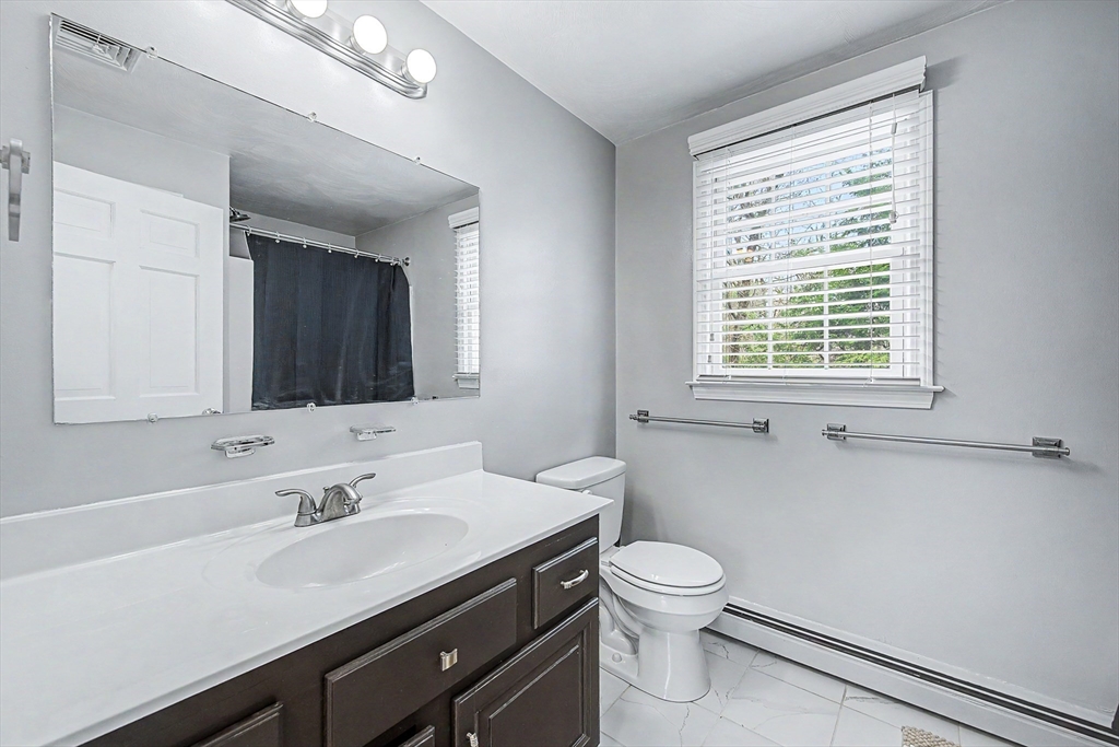 1 Coburn Road Hopkinton, MA 01748 - Photo 30 of 42 a bathroom with a toilet a sink a mirror and a window
