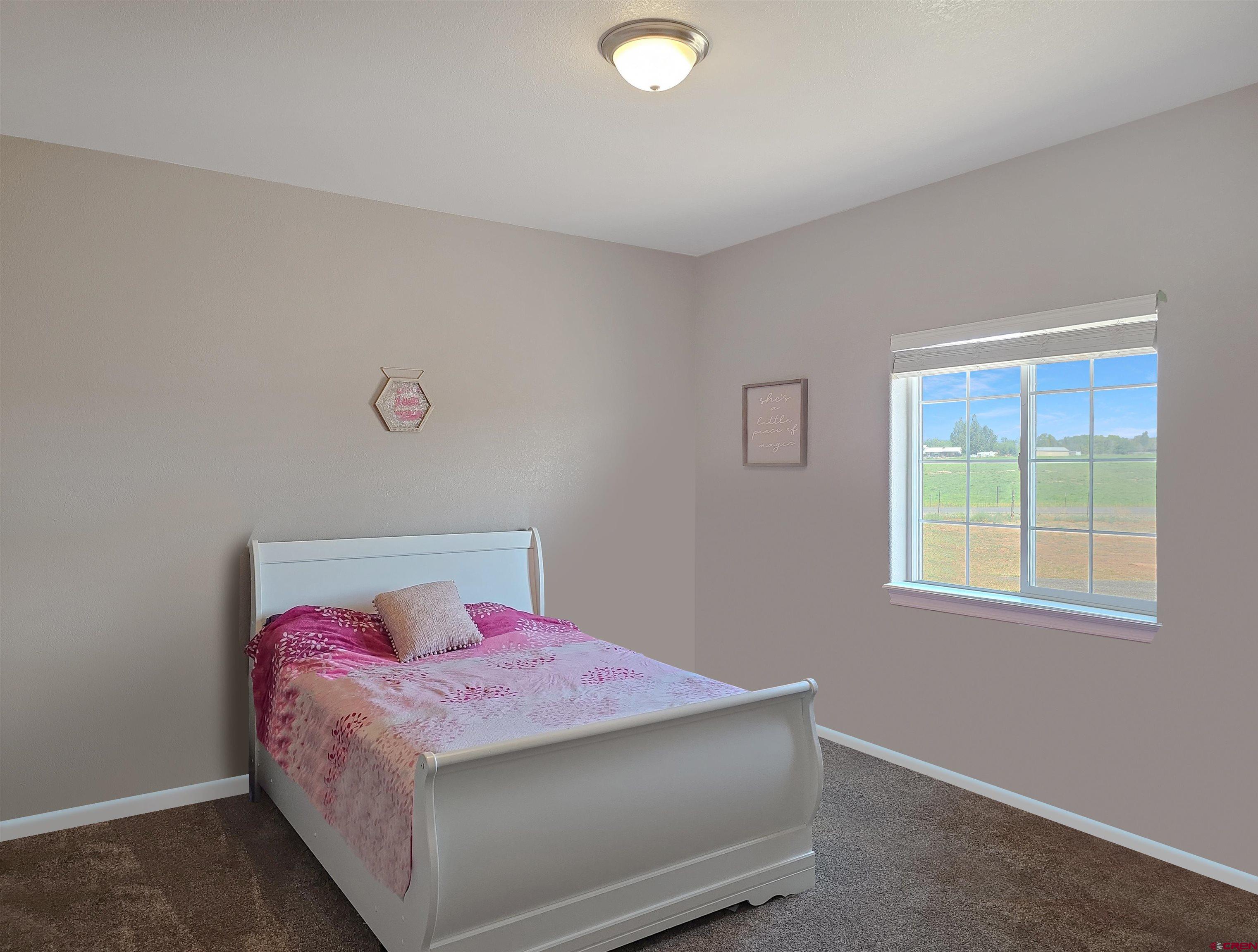 26030 Road North Cortez, CO 81321 - Photo 26 of 39 a bedroom with a bed and a window