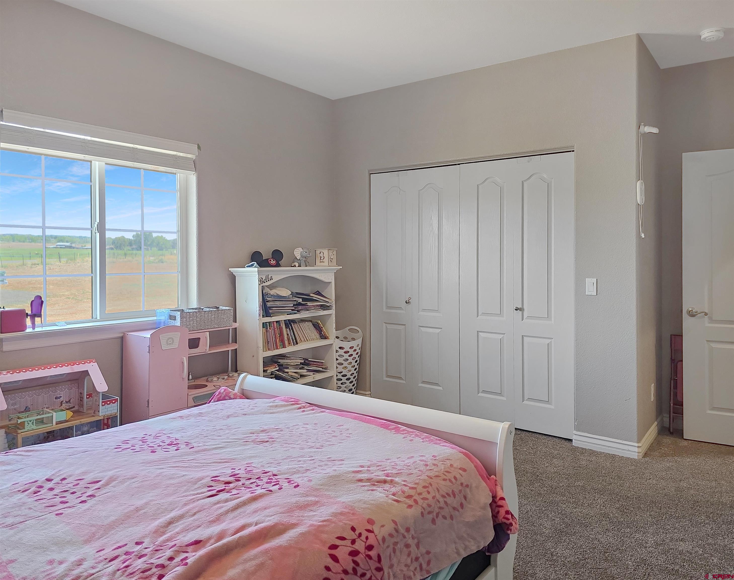 26030 Road North Cortez, CO 81321 - Photo 27 of 39 a bedroom with a bed and a dresser next to a window