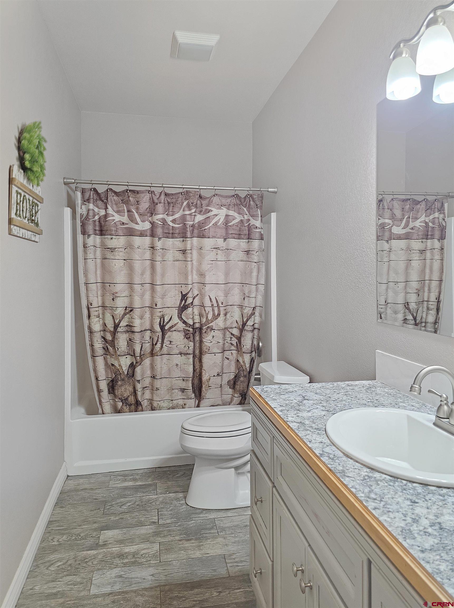 26030 Road North Cortez, CO 81321 - Photo 30 of 39 a bathroom with a granite countertop sink a toilet and a shower